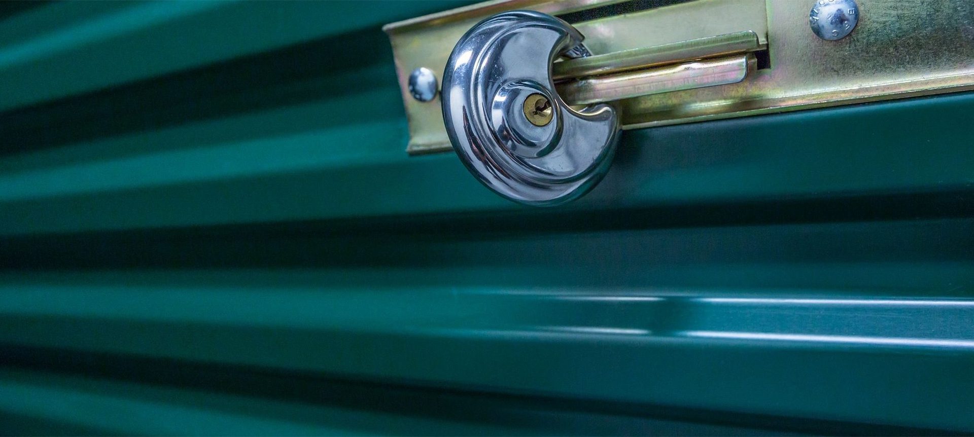A close up of the key on a green door.
